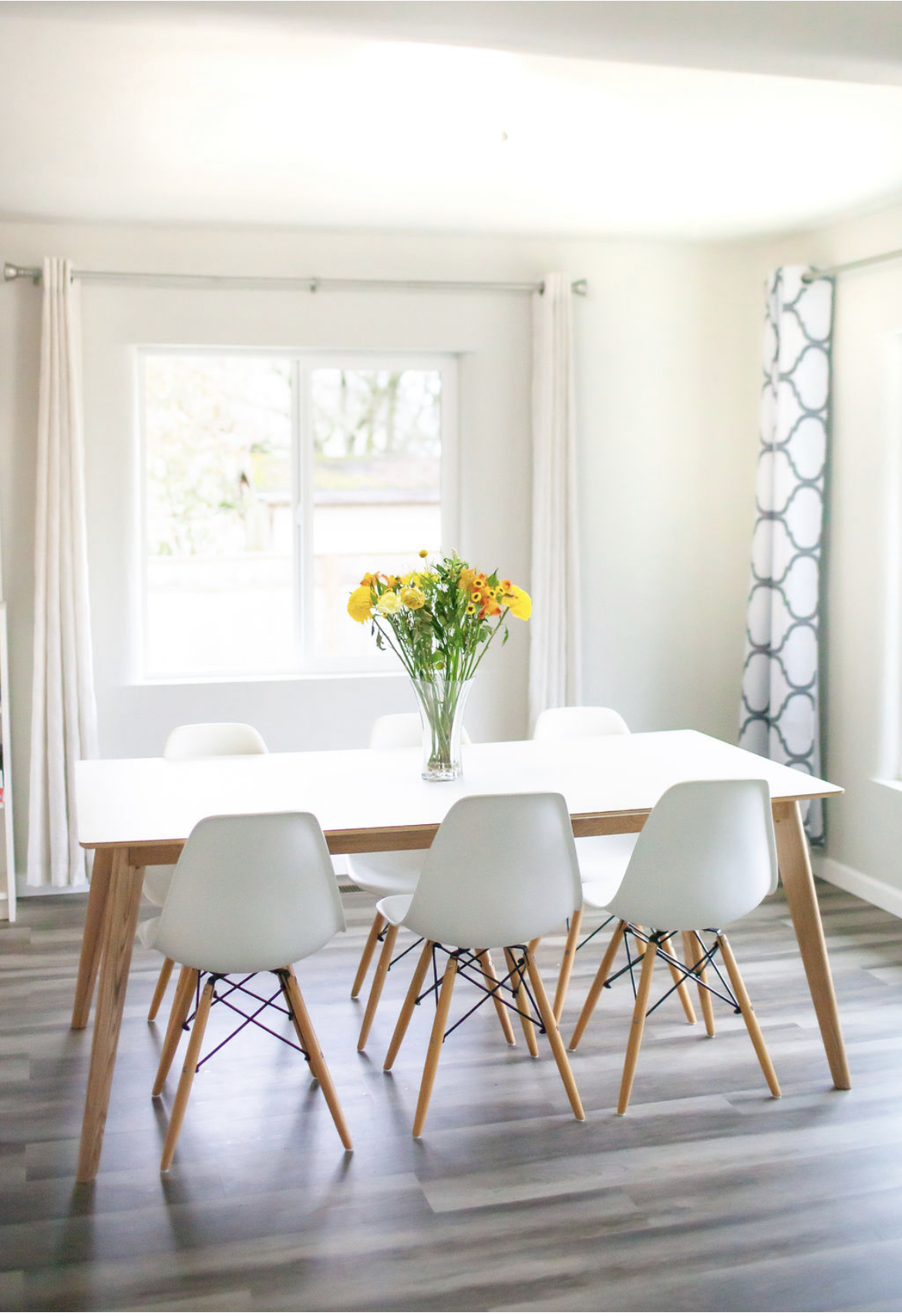 Dining table set beside a bright window at Everyday Grace